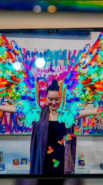 Gallery visitor experiencing AMOR angel painting through augmented reality on tablet via Ivan Guaderrama AR app
