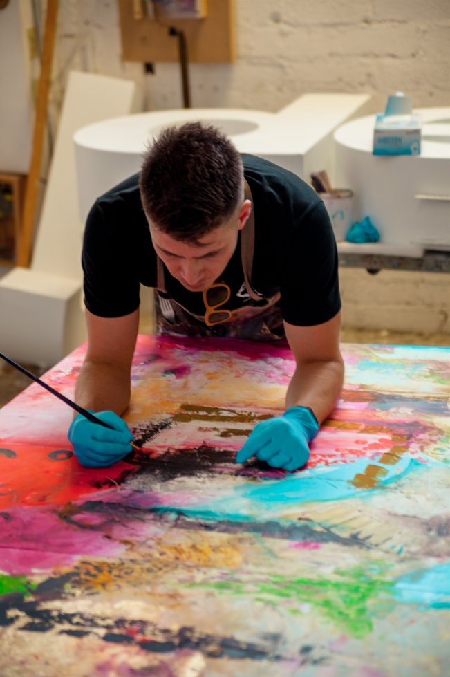 Gallery visitor playing Ivan Guaderrama's interactive piano painting — touch-sensor activated original artwork