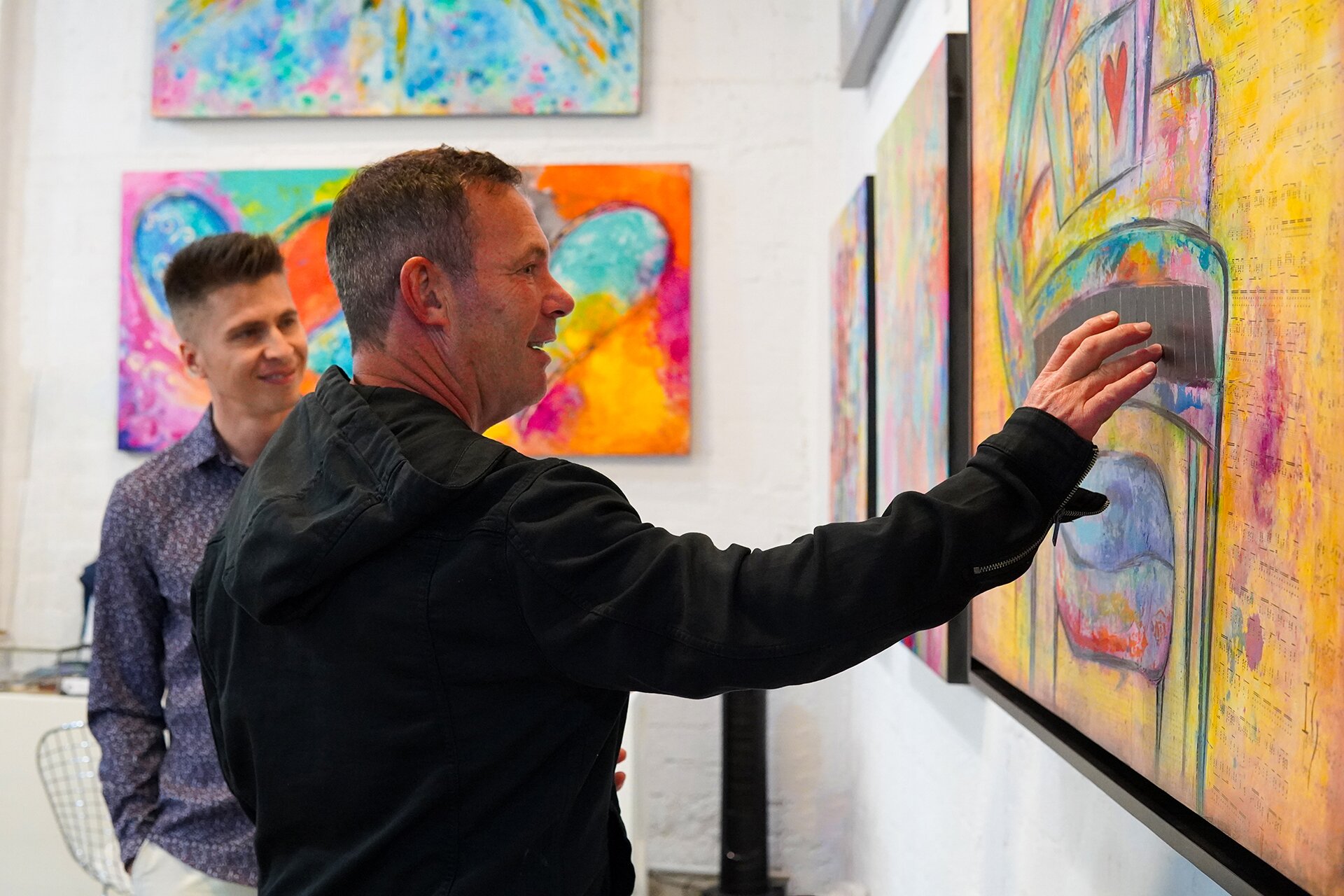 Gallery visitor touching the embedded sensor on Ivan Guaderrama's interactive original painting at his San José del Cabo gallery